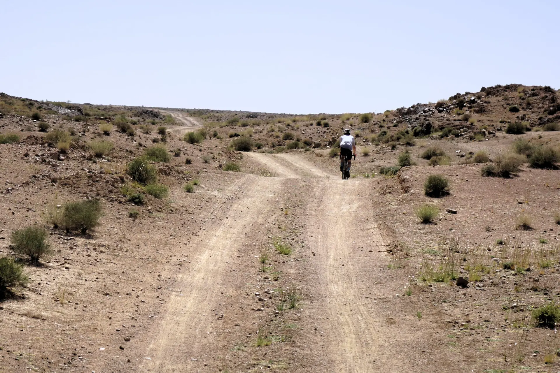 Gravel cyclists riding open roads through Morocco with dramatic landscape scenery